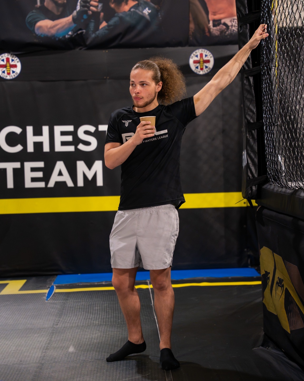 Ellis holding pads during sparring in the Manchester Top Team cage